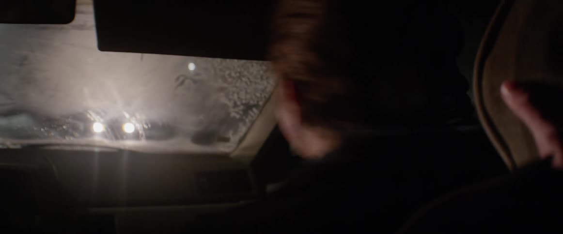 Man sits in a vehicle and bobs his head back and forth violently
