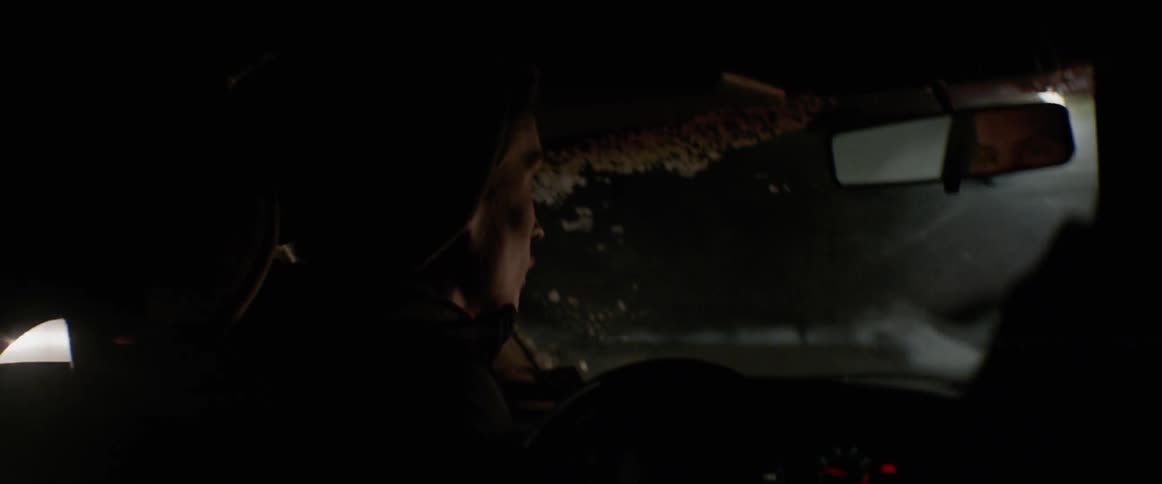 The man looks back while steering at night