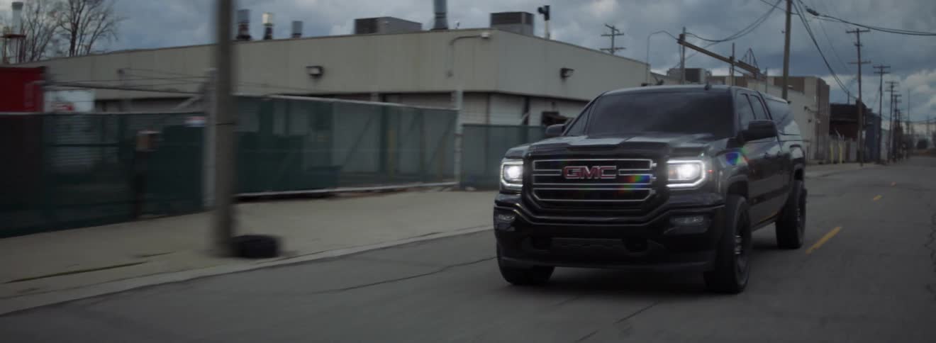 Truck travels down the road with its headlights on