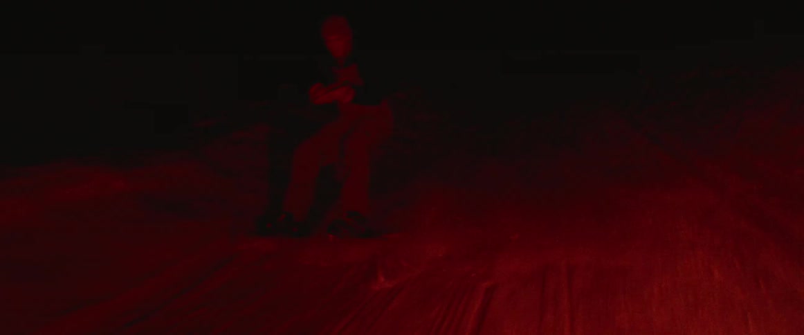 A man riding a snowboard is being towed outside in winter at night