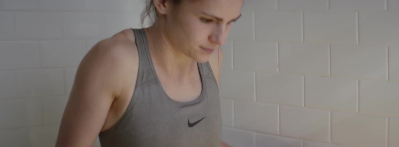 The woman takes a deep breath after looking down