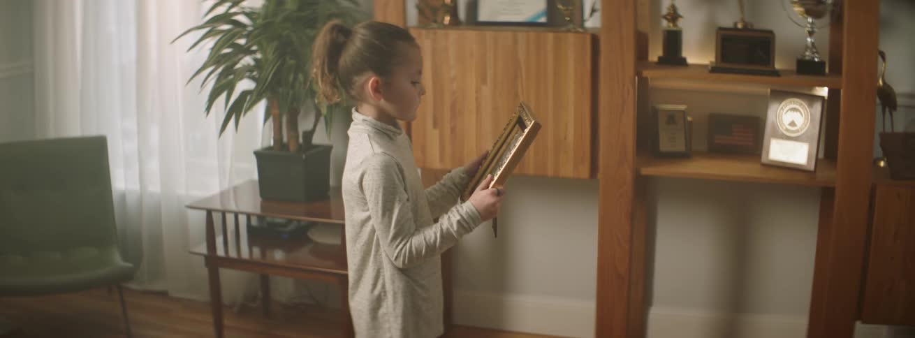 Girl looks at a framed photograph