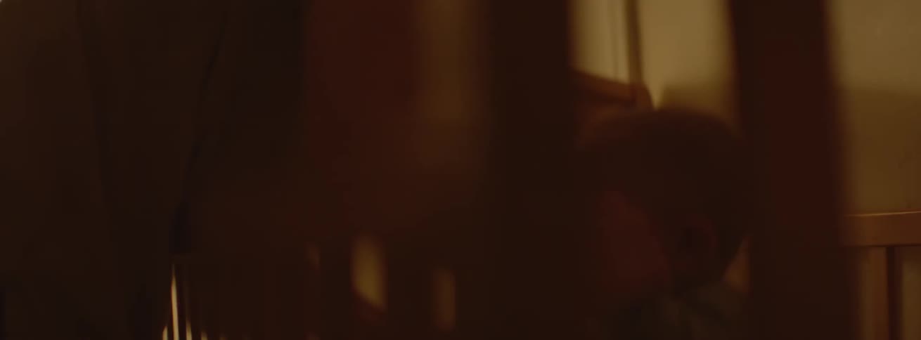 The woman picks the baby up from the crib