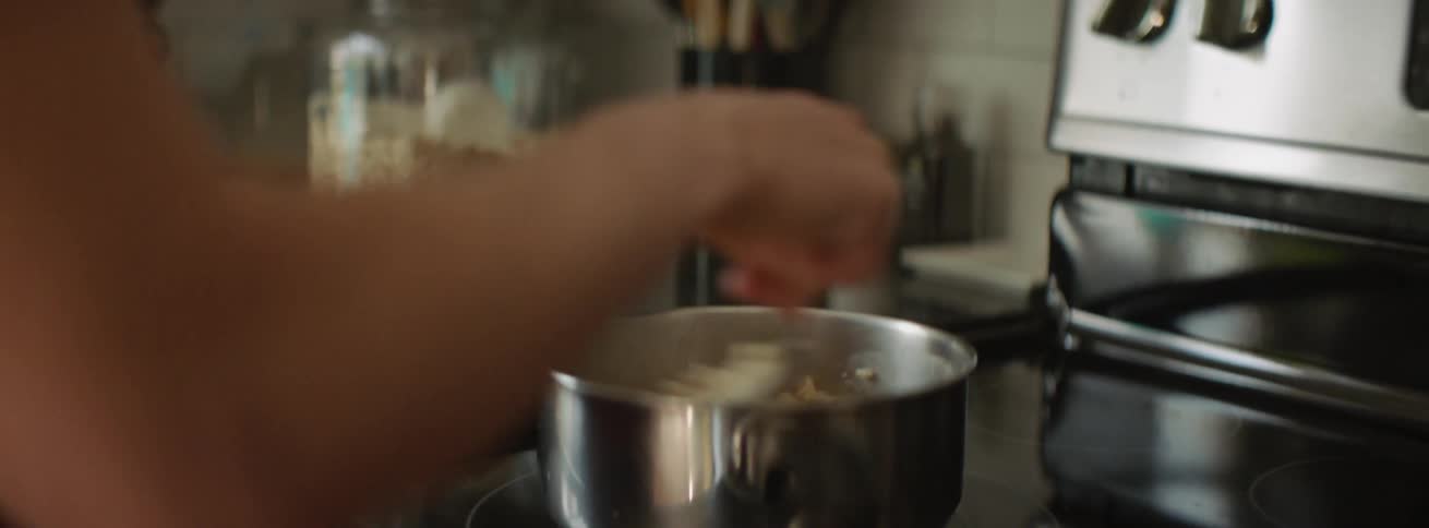 A woman cooks on the stove