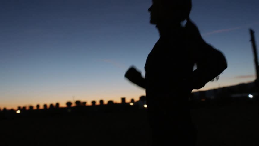 Woman jogs outside at dusk