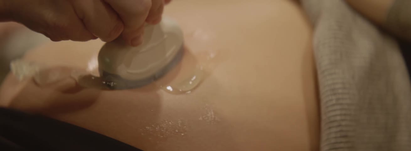 A woman is having a test on her pregnant belly