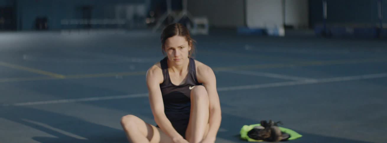 An athlete unlaces her cleats