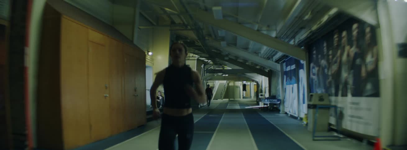 The woman races fast on the track inside