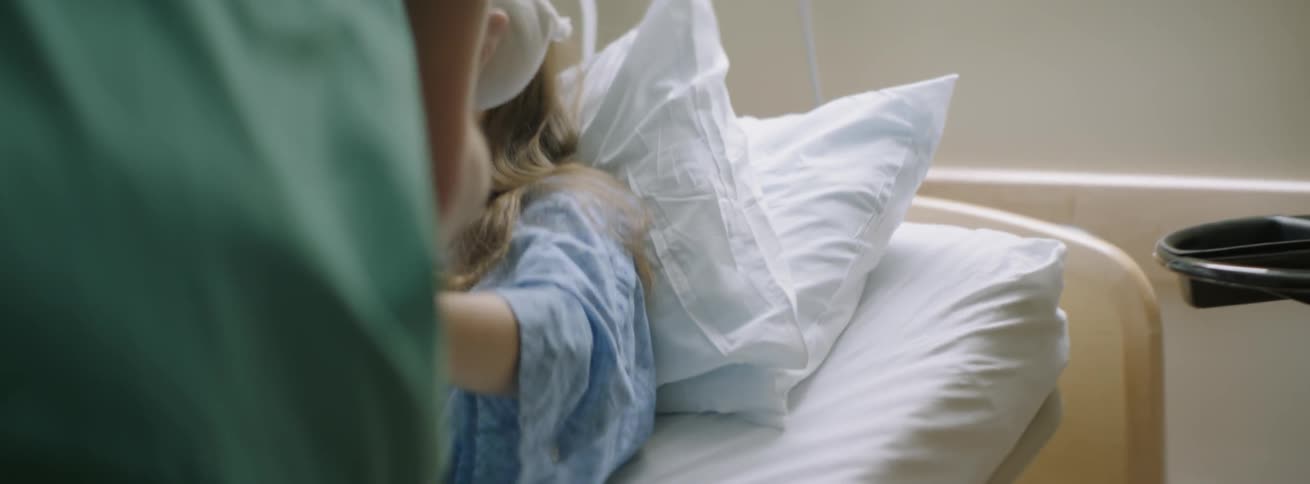 The woman smiles as she holds the baby in the hospital