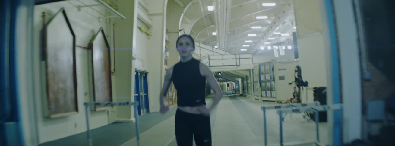 The woman runs fast through the gym track