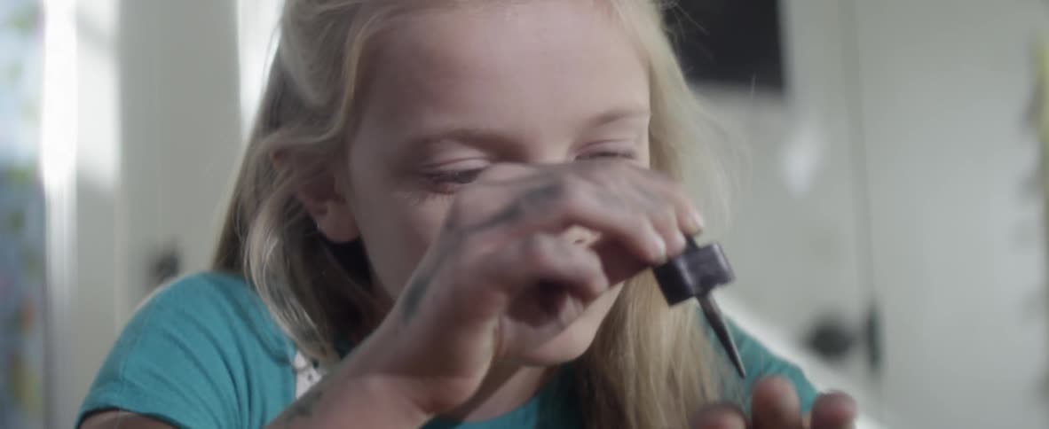 A child is drawing on herself