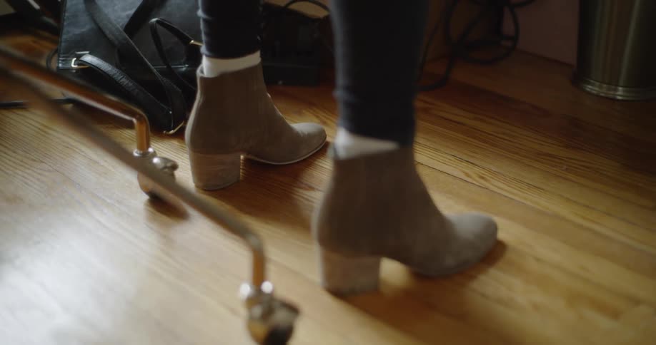 A person taps their foot on the wooden floor