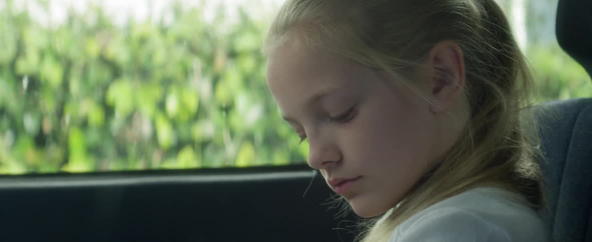 A child puts on her seatbelt