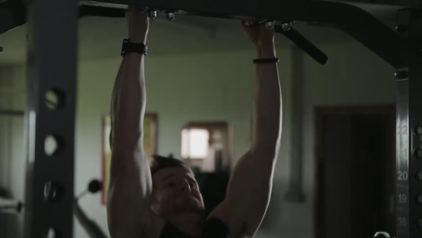 Man doing chin ups in a gym
