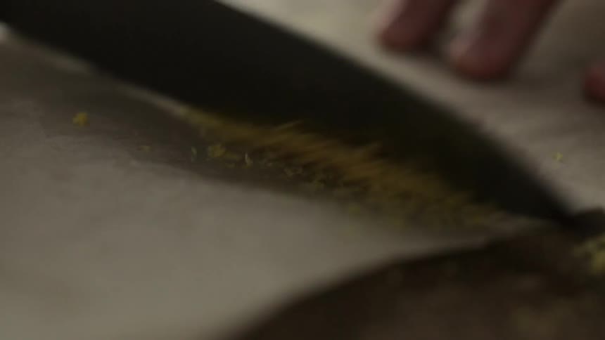 Someone is scraping up citrus zest with a knife