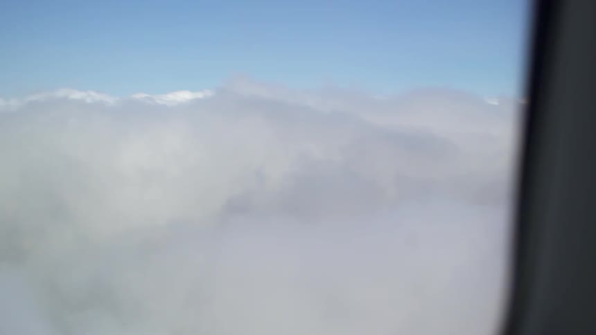 Fluffy white clouds seen from a plane window
