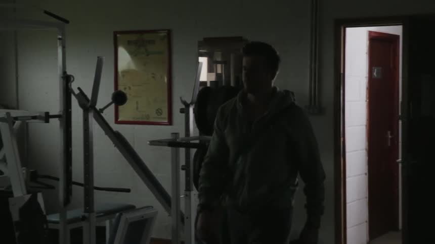 Man walks into a dark gym