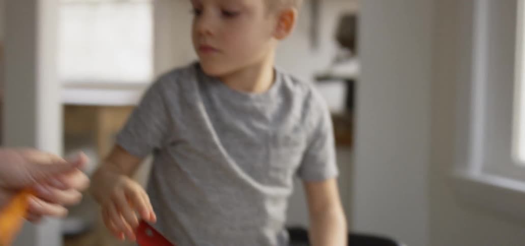 A child sprinkles cheese on a salad