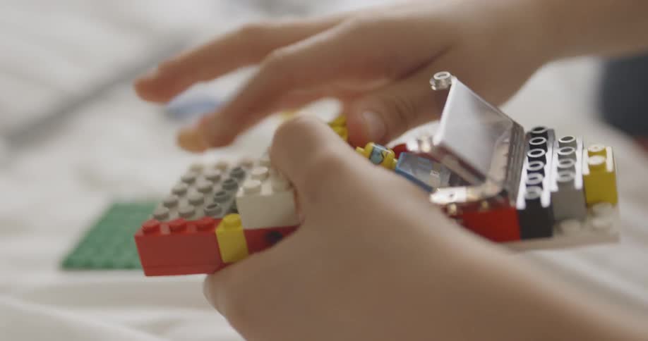 A young child plays with lego toys