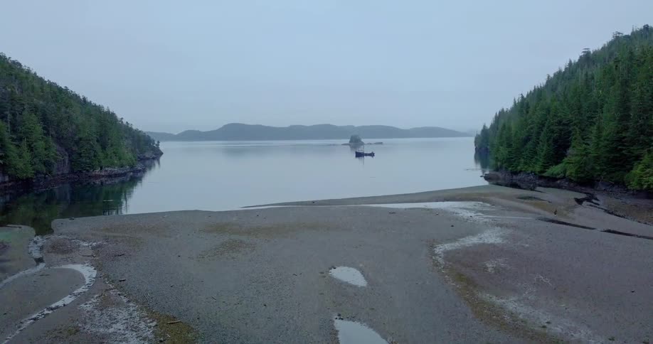 A boat is sitting docked in a remote inlet at dusk
