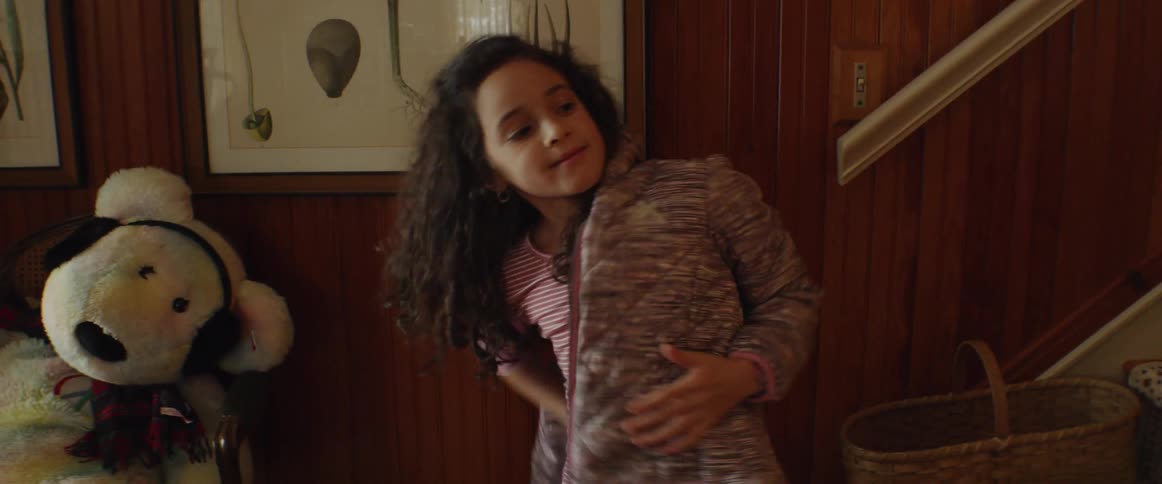 Young girl puts on her jacket and lifts her hair over the collar
