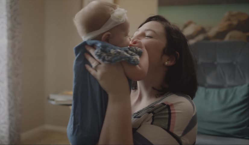 A woman holds and kisses a baby