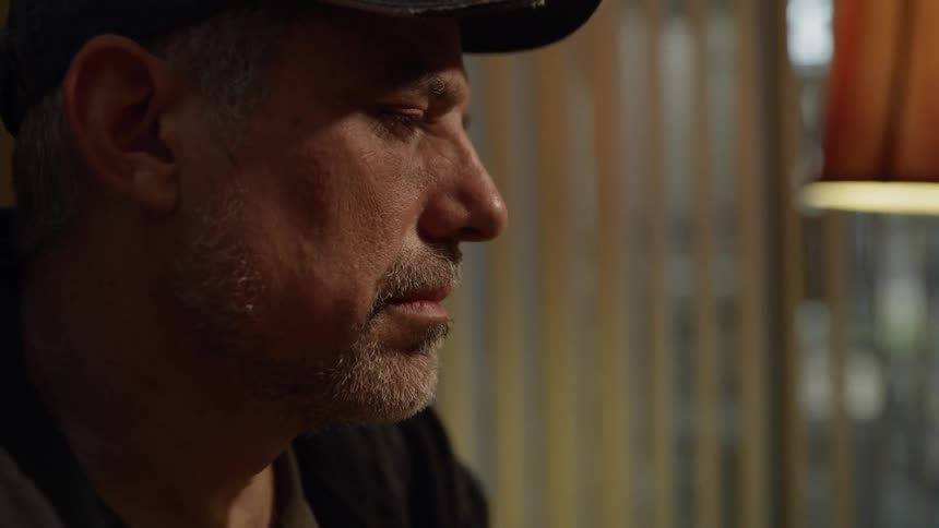 Man wearing a hat stares ahead