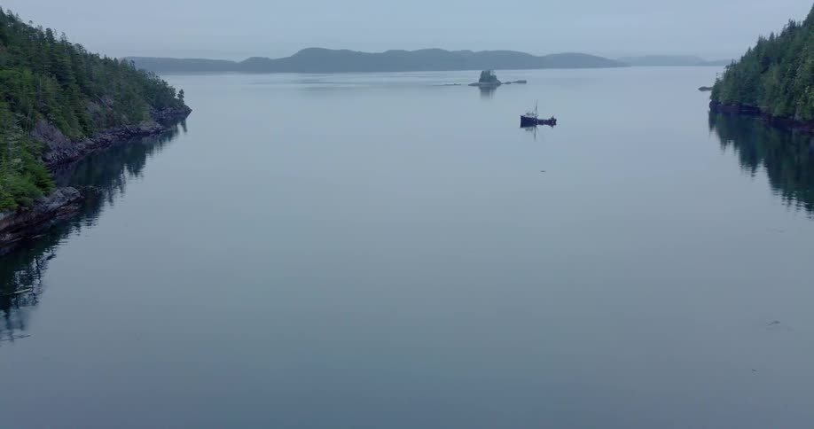 Boat floating on a large body of water on a cloudy day