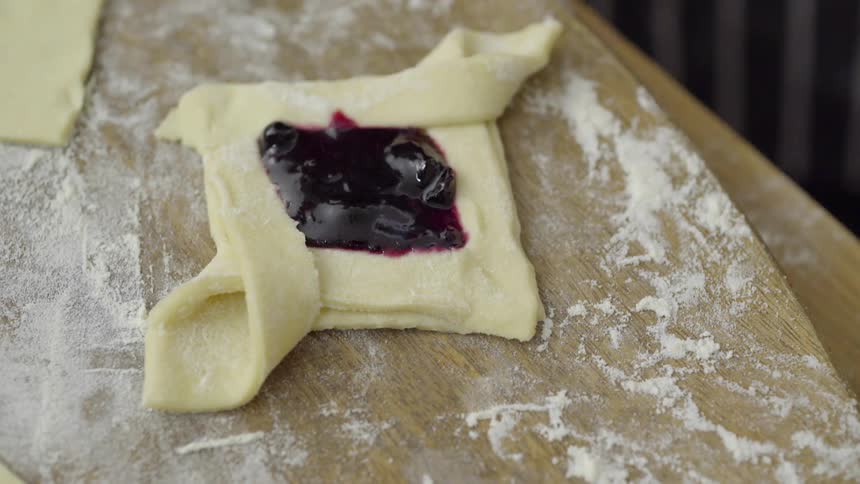 Someone is making a pastry stuffed with fruit