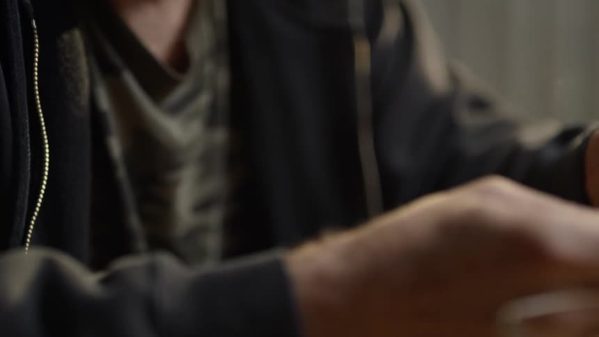 Man holds wedding rings while drinking whiskey