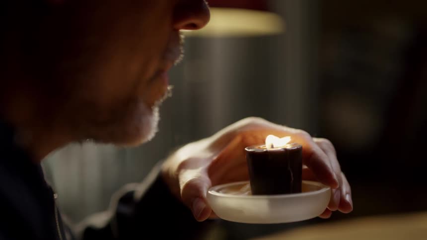 A man blows out a candle