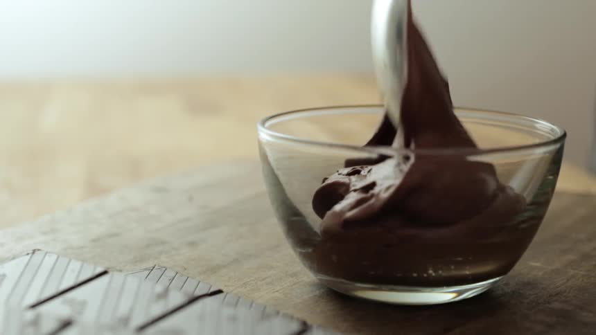 Man dumping a brown substance in a glass bowl
