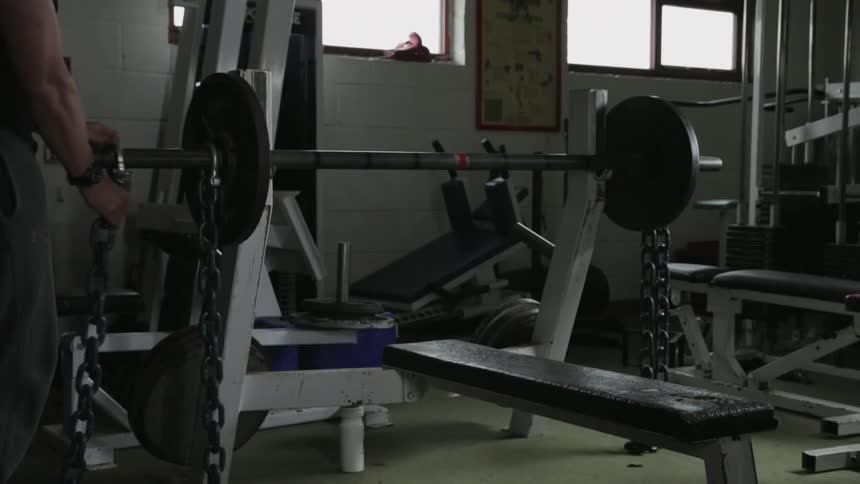 Man secures some weights before sitting down to start lifting