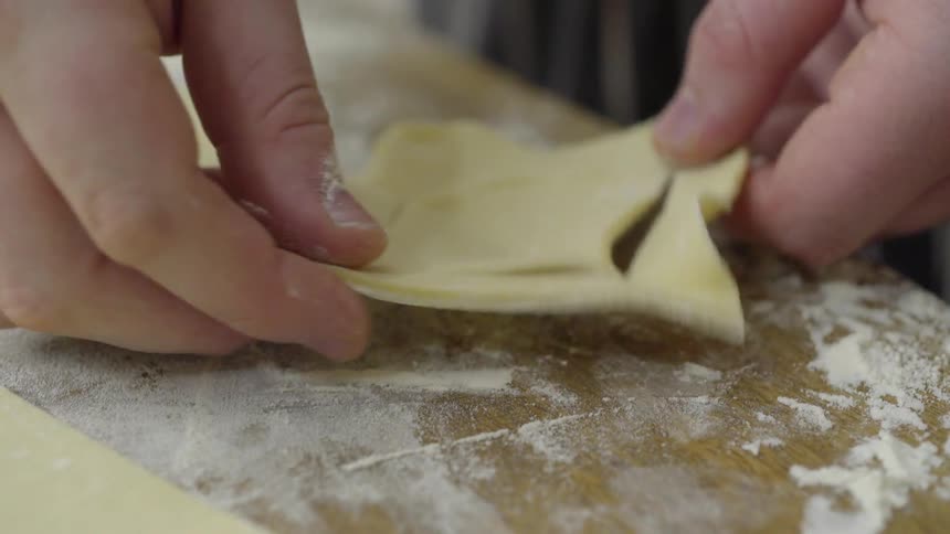 Person folding some food and cutting it