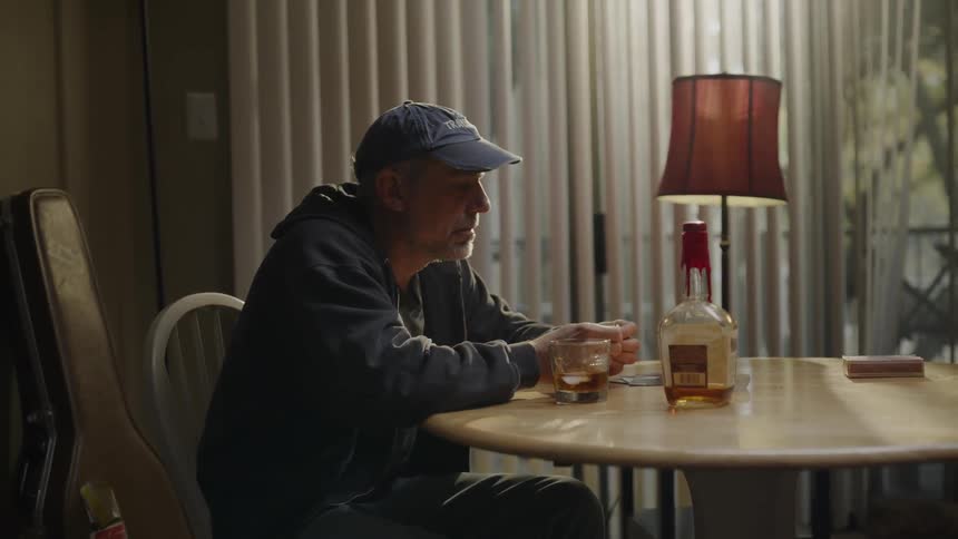 Man sits at a table looking at a ring