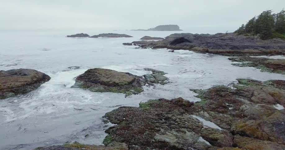 The tide flows towards the rocky shore