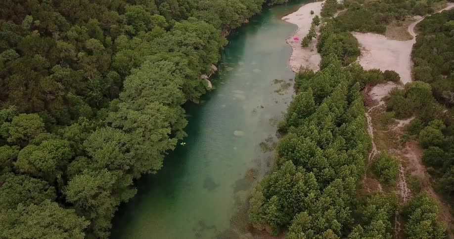 The river is calm near the forest