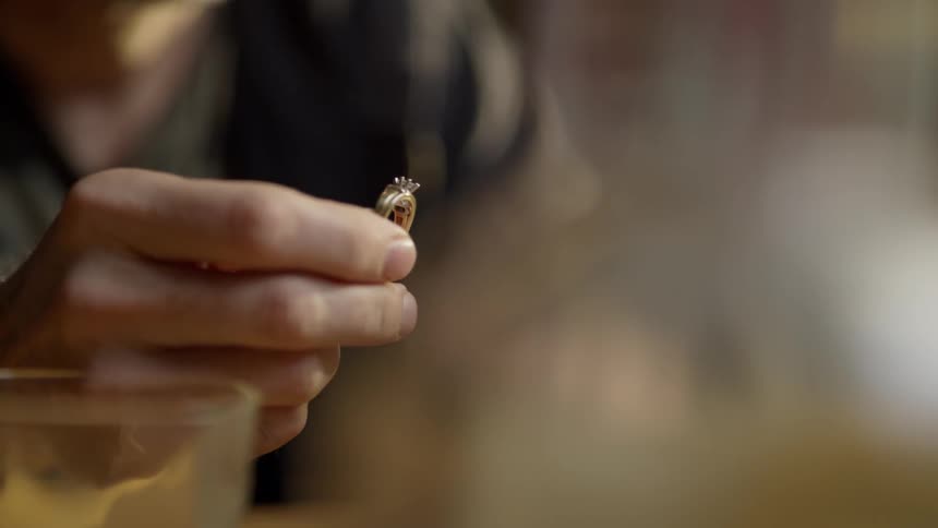 The man holds the ring up examining it