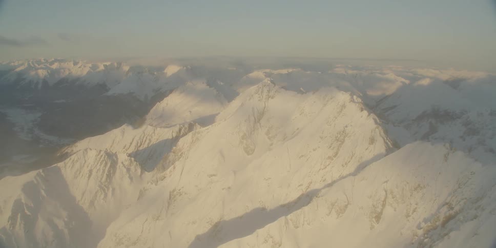 The mountain range is covered with fog below