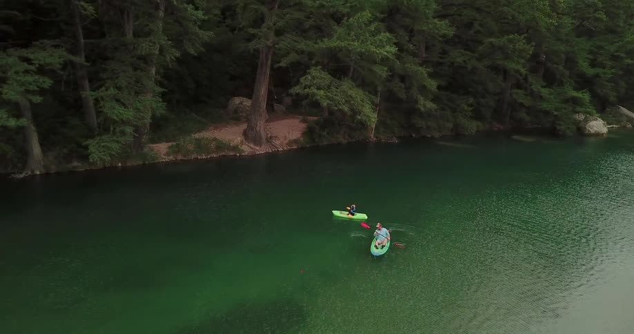 Two people kayaking down a river