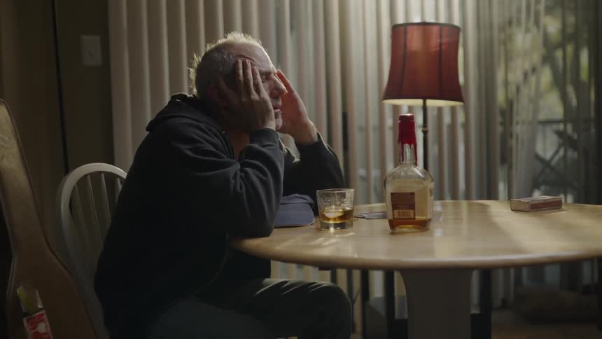 A man drinks alone at a table