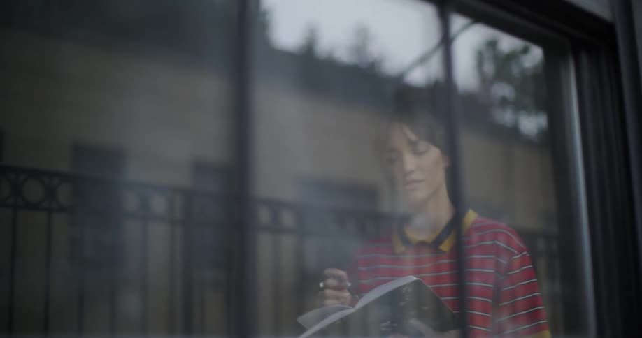 Pacing woman sings while looking at a notebook