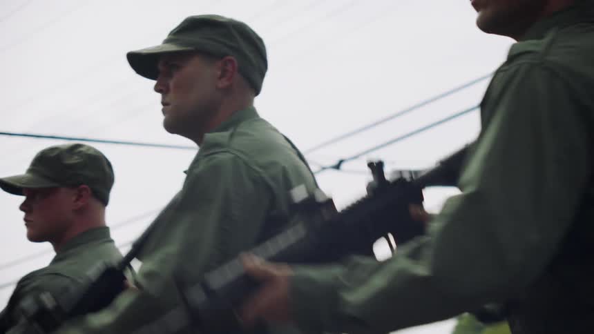The soldiers line up and point their rifles together