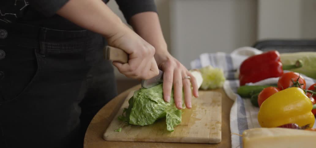 Man cuts lettuce on a cutting board
