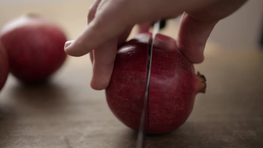 Pomegranate being sliced in half