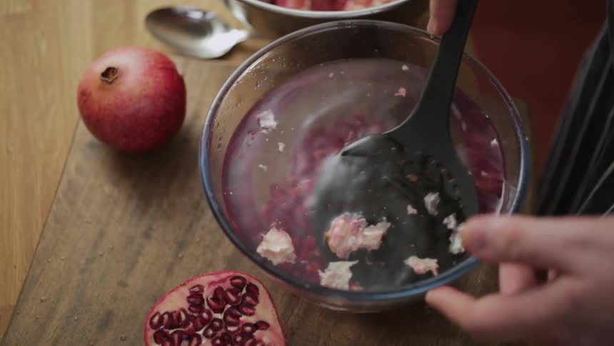 Person straining something out of a bowl of water