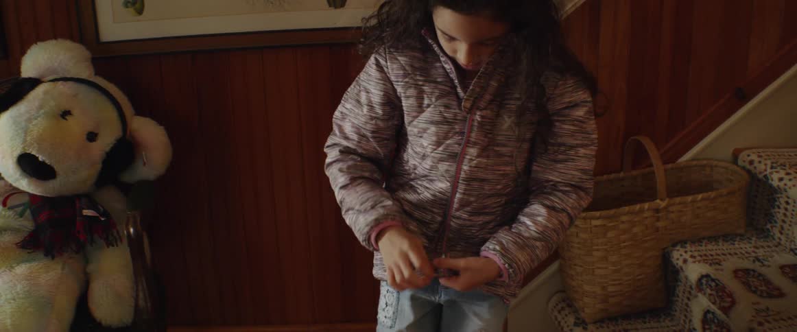 A girls zips up her winter coat