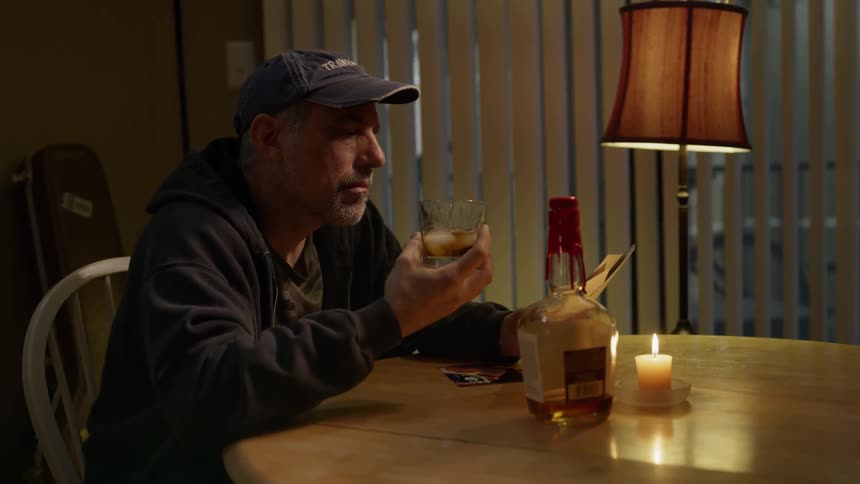A man drinks alone at a table