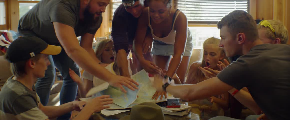Men and women talk excitedly looking at maps