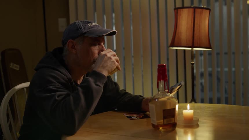 A man drinks alone at a table